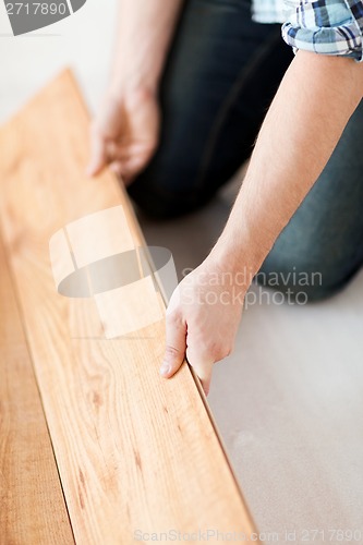 Image of close up of male hands intalling wood flooring