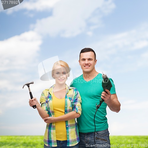 Image of smiling couple with hammer and drill