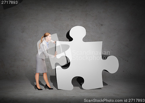 Image of busy businesswoman pushing puzzle piece