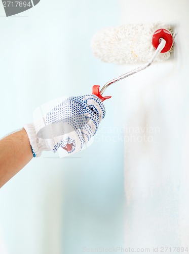 Image of close up of male in gloves painting wall