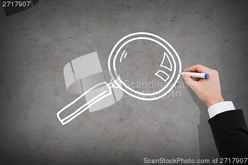 Image of close up of businessman drawing magnifying glass