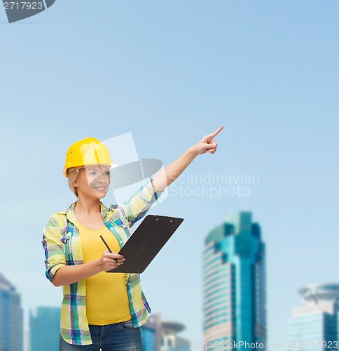 Image of smiling woman in helmet with clipboard