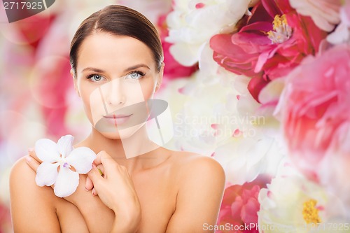 Image of relaxed woman with orhid flower