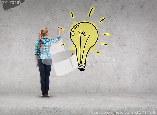 Image of smiling young woman writing on virtual screen