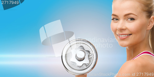 Image of smiling woman with heavy steel dumbbell