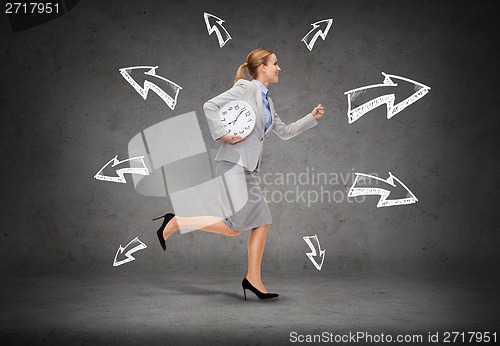 Image of smiling young businesswoman with clock running