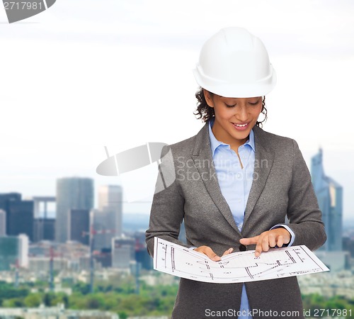 Image of businesswoman in white helmet with blueprint