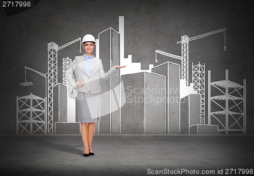 Image of businesswoman in helmet showing construction site