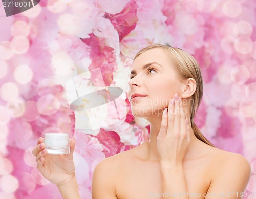 Image of woman applying cream on her skin