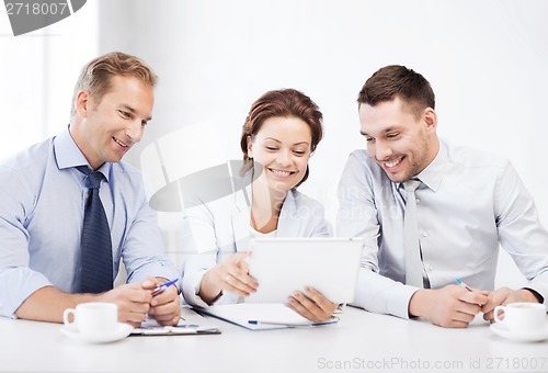 Image of business team looking at tablet pc in office