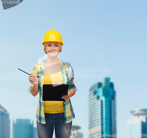 Image of smiling woman in helmet with clipboard