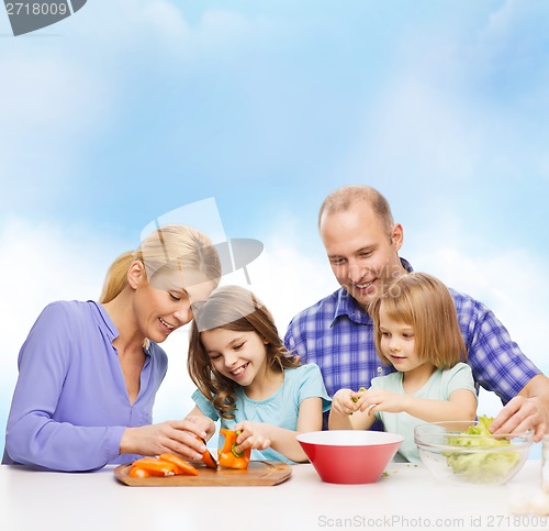 Image of happy family with two kids making dinner at home