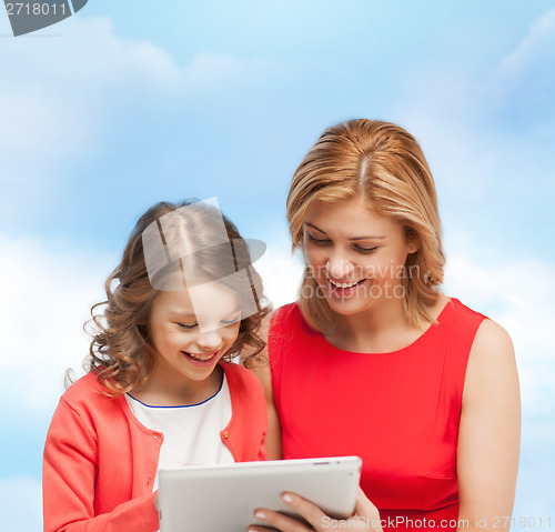 Image of smiling mother and daughter with tablet pc