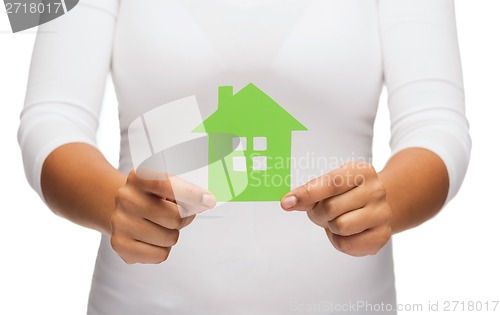 Image of woman hands holding green house