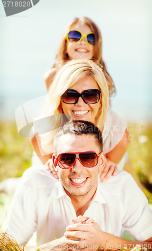 Image of happy family with blue sky and green grass