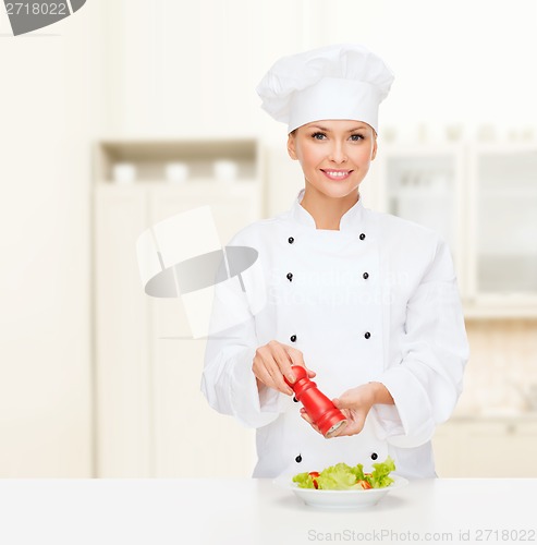 Image of smiling female chef with preparing salad