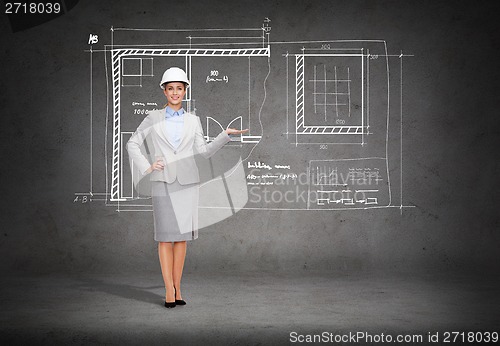 Image of businesswoman in helmet showing blueprint