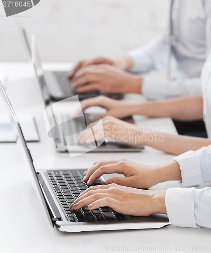 Image of group of people working with laptops in office