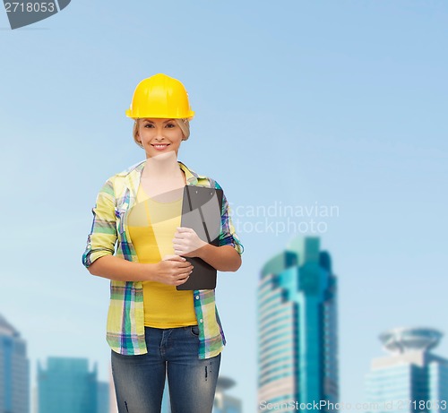 Image of smiling woman in helmet with clipboard