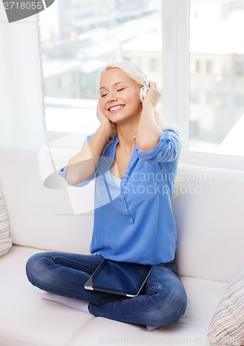 Image of woman with tablet pc and headphones at home
