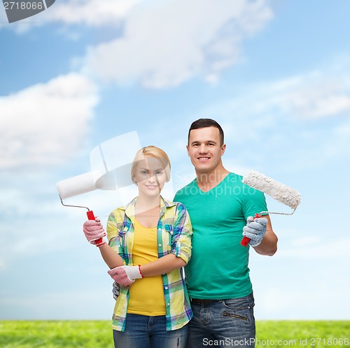Image of smiling couple in gloves with paint rollers