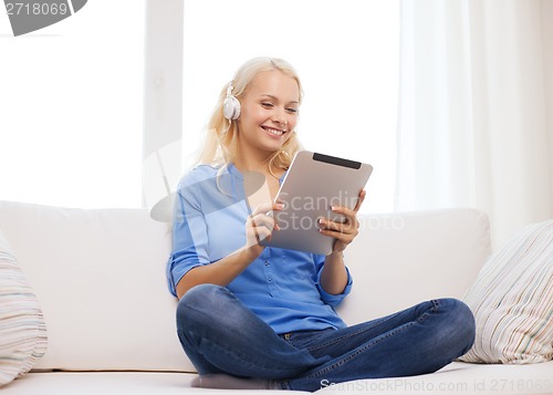 Image of woman with tablet pc and headphones at home