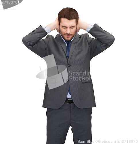 Image of annoyed businessman covering ears with his hands