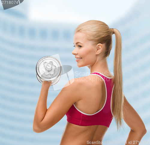 Image of smiling woman with heavy steel dumbbell