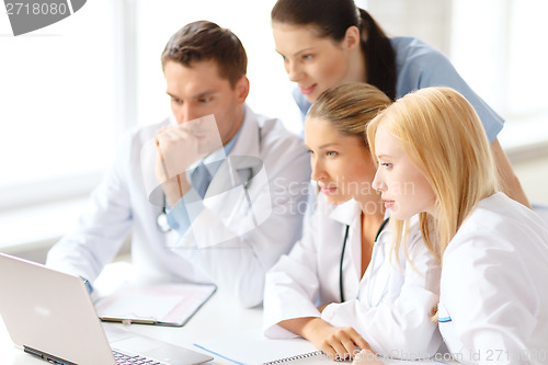 Image of busy group of doctors looking at laptop computer