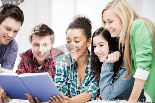 Image of students reading book at school