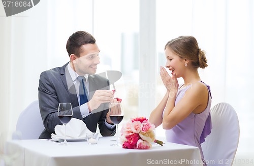 Image of man proposing to his girlfriend at restaurant