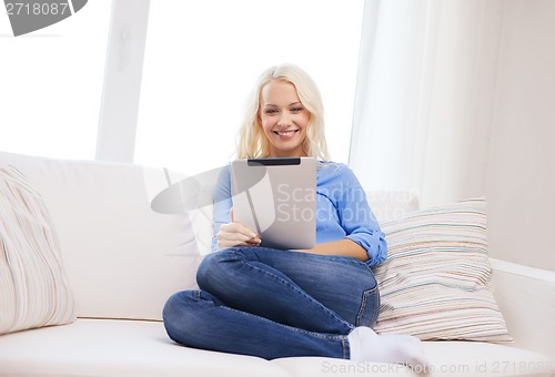 Image of smiling woman with tablet pc computer at home