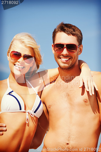 Image of happy couple in sunglasses on the beach