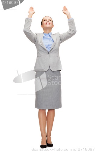 Image of businesswoman pushing up something imaginary