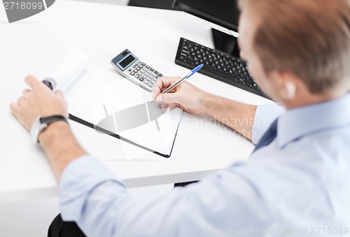 Image of businessman with notebook and calculator