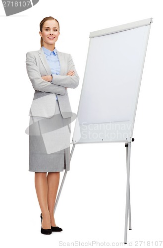 Image of smiling businesswoman standing next to flipboard