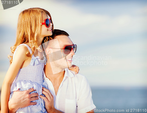 Image of happy father and child in sunglasses over blue sky
