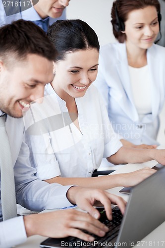 Image of group of people working with laptops in office