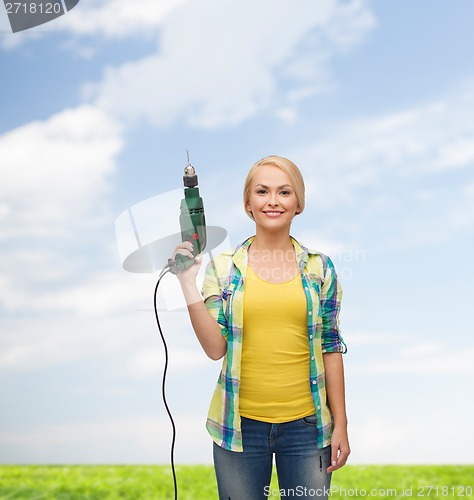 Image of smiling woman with drill machine