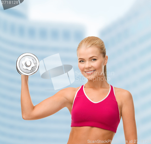 Image of smiling woman with heavy steel dumbbell