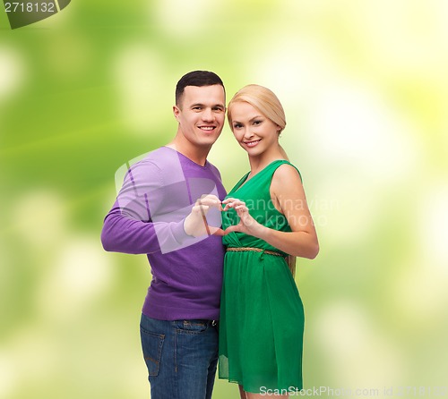 Image of smiling couple showing heart with hands