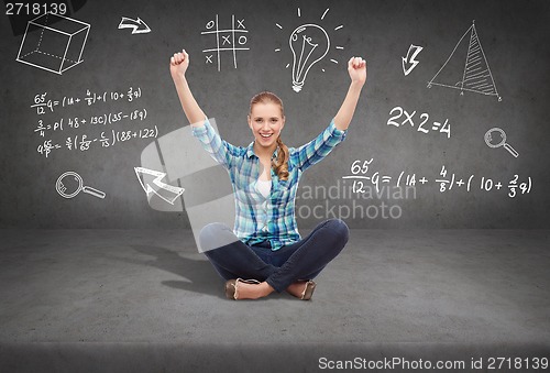 Image of young woman in casual clothes sitting on floor