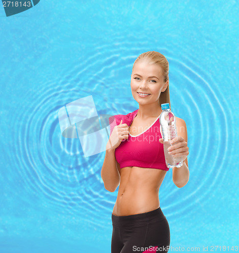 Image of sporty woman with bottle of water and towel