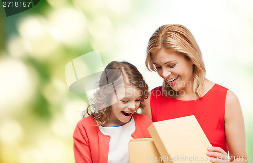 Image of smiling mother and daughter opening gift box