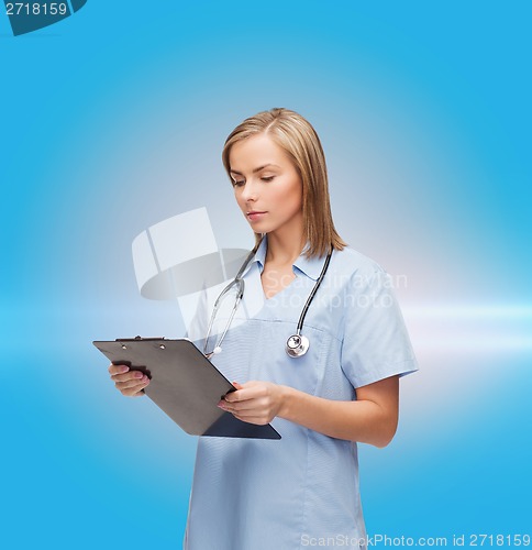 Image of smiling female doctor or nurse with clipboard