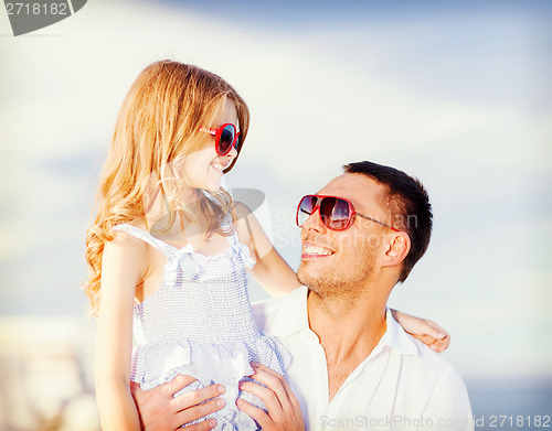 Image of happy father and child in sunglasses over blue sky