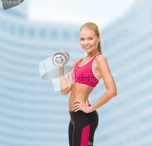 Image of smiling woman with heavy steel dumbbell