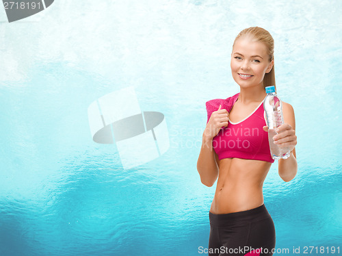 Image of sporty woman with bottle of water and towel