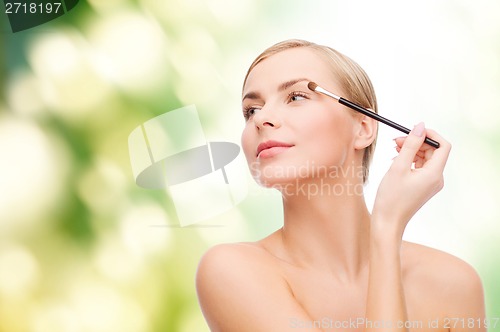 Image of beautiful woman with makeup brush