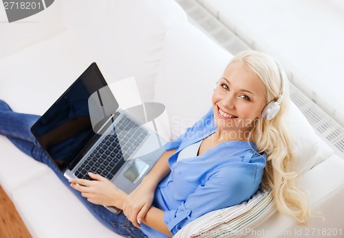 Image of woman with laptop computer and headphones at home